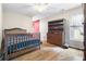 A lovely bedroom with a wooden crib, dresser, and light hardwood flooring at 3993 Amberley Ln, Marietta, GA 30062