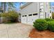 Attached two-car garage with white doors, set against a backdrop of mature landscaping at 3993 Amberley Ln, Marietta, GA 30062