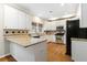 Well-lit kitchen features white cabinetry, granite countertops, stainless steel appliances, and hardwood floors at 3993 Amberley Ln, Marietta, GA 30062
