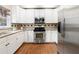Modern kitchen features stainless steel appliances, white cabinets, granite countertops, and hardwood floors at 3993 Amberley Ln, Marietta, GA 30062