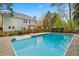 Beautiful in-ground pool surrounded by a fence, deck, and two-story home with lush landscaping at 3993 Amberley Ln, Marietta, GA 30062