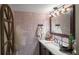 Charming bathroom featuring butterfly wallpaper, framed mirror, white countertops, and dark brown cabinetry at 1354 Larson Sw Ct, Marietta, GA 30064