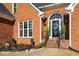 Charming brick home entrance with steps, a decorative front door, and manicured landscaping at 1354 Larson Sw Ct, Marietta, GA 30064