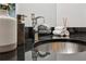 Bathroom sink with chrome faucet atop a black countertop, accessorized with decorative soap dispenser and rolled towels at 1661 La France Ne St # 102, Atlanta, GA 30307
