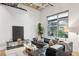 Bright living room featuring a leather couch, large window, modern decor, and white walls at 1661 La France Ne St # 102, Atlanta, GA 30307