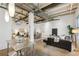 Open-concept living space with exposed beams, polished concrete floors, a dining area, and a black leather couch at 1661 La France Ne St # 102, Atlanta, GA 30307