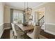Traditional dining room features elegant wainscoting, stylish chandelier, and a large window at 2687 Ashford Ne Rd, Brookhaven, GA 30319
