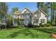 Charming two-story home featuring a manicured lawn, beautiful landscaping, and a classic brick facade with shuttered windows at 2687 Ashford Ne Rd, Brookhaven, GA 30319