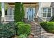 Close-up of an elegant front door with sidelights, brick stairs, and manicured landscaping at 2687 Ashford Ne Rd, Brookhaven, GA 30319