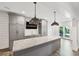 Entertainers kitchen and bar area with a marble countertop and pendant lights at 2687 Ashford Ne Rd, Brookhaven, GA 30319
