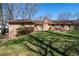 Features a beautiful backyard with lush green grass, mature trees, and a brick house at 5836 Trailwoods Ct, Stone Mountain, GA 30087