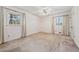 Bedroom with neutral carpeting, two windows, and closet doors at 5836 Trailwoods Ct, Stone Mountain, GA 30087