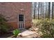 A brick home exterior, featuring a fenced yard and small plants, showcasing outdoor charm at 5836 Trailwoods Ct, Stone Mountain, GA 30087