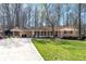 Charming single-story home featuring a brick facade, a carport, and a lush, well-maintained lawn at 5836 Trailwoods Ct, Stone Mountain, GA 30087