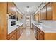 Galley kitchen with white countertops, wood cabinets and vintage appliances at 5836 Trailwoods Ct, Stone Mountain, GA 30087