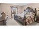 Charming bedroom with a decorative wooden bed frame, luxurious linens, and a side table at 612 Kristen Ct, Mcdonough, GA 30252