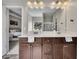 Bathroom with double vanity sinks with a large mirror above and a doorway leading to the bedroom at 133 Prominence Ct, Canton, GA 30114