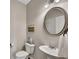 Charming bathroom featuring a toilet, sink, round mirror, and light fixture at 133 Prominence Ct, Canton, GA 30114