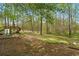 A vast backyard with mature trees and an old playset providing a serene and private outdoor space at 2840 Ivy Mill Dr, Buford, GA 30519