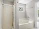 Bathroom with a glass door shower, soaking tub, and window at 2840 Ivy Mill Dr, Buford, GA 30519