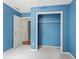 Bright bedroom featuring neutral carpet, blue walls, and a closet with ample storage space at 2840 Ivy Mill Dr, Buford, GA 30519
