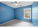 Bedroom with bright blue walls, neutral carpeting, and large window with tree view at 2840 Ivy Mill Dr, Buford, GA 30519