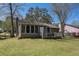 Backyard featuring a small deck, screened-in porch, and fenced yard with mature trees and green grass at 910 Brandon Hill Way, Jonesboro, GA 30238