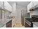 Galley kitchen with stainless steel appliances, granite counters, tile floors, and open to the dining area at 910 Brandon Hill Way, Jonesboro, GA 30238