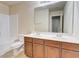 Bathroom featuring a double sink vanity with cherry cabinets, a toilet and a bathtub with shower at 2205 Capella Sw Cir, Atlanta, GA 30331