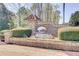 Community entrance with a stone sign, lush landscaping, and colorful flowers, creating an inviting and appealing atmosphere at 2205 Capella Sw Cir, Atlanta, GA 30331