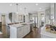 Open kitchen featuring a large island, stainless steel appliances, and a seamless flow to the staircase and dining area at 4256 Azalea Ridge Way, Hoschton, GA 30548