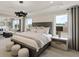 Bright main bedroom featuring tray ceiling, with decorative lighting, ample windows, and view to living room at 4256 Azalea Ridge Way, Hoschton, GA 30548