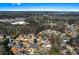 Expansive aerial view of a community surrounded by lush greenery with blue skies in the background at 525 James Lee Dr, Suwanee, GA 30024