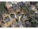 A bird's eye view showcases the rooftops and landscaping of several homes nestled amongst lush green trees at 525 James Lee Dr, Suwanee, GA 30024