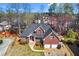 Aerial view of brick home, showcasing its position on a lot with mature trees and proximity to neighboring houses at 525 James Lee Dr, Suwanee, GA 30024