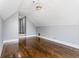 Attic room with hardwood floors, neutral paint, ceiling fan, and hallway access at 525 James Lee Dr, Suwanee, GA 30024