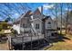Home's backyard showcasing a spacious deck for entertaining and a shaded patio area with outdoor furniture at 525 James Lee Dr, Suwanee, GA 30024