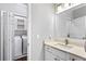 Bright bathroom features a white vanity, modern sink faucet, mirror, and access to a laundry closet at 525 James Lee Dr, Suwanee, GA 30024
