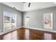 Large bedroom with hardwood floors, three windows for lots of natural light, and neutral walls at 525 James Lee Dr, Suwanee, GA 30024