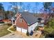 Aerial view of home's exterior highlighting the roof, brick and siding accents, lawn, and two-car garage at 525 James Lee Dr, Suwanee, GA 30024