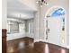 View of the foyer with dark wood flooring, arched front door, and chandelier, leading into the living room at 525 James Lee Dr, Suwanee, GA 30024