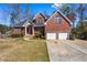Beautiful two-story brick home with a well-manicured lawn, two-car garage, and a welcoming red front door at 525 James Lee Dr, Suwanee, GA 30024