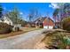 View of the brick house from the driveway, featuring a well-maintained lawn, garage, and a welcoming front entrance at 525 James Lee Dr, Suwanee, GA 30024
