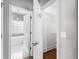 Hallway view to a modern bathroom featuring a soaking tub, bright tile, and stylish fixtures at 525 James Lee Dr, Suwanee, GA 30024