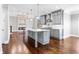 Open-concept kitchen and living area with modern grey cabinets, a spacious island, and dark hardwood floors throughout at 525 James Lee Dr, Suwanee, GA 30024