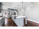 Bright kitchen boasts an island with white countertop, stainless steel sink, and pendant lighting at 525 James Lee Dr, Suwanee, GA 30024