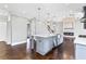 Kitchen island includes a stainless steel sink and seating, with a fireplace in the background at 525 James Lee Dr, Suwanee, GA 30024