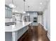 Bright kitchen features an island with a stainless steel sink, granite countertops, and gray cabinets at 525 James Lee Dr, Suwanee, GA 30024