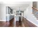 View of the kitchen, featuring blue-grey cabinets, a center island, and hardwood flooring adjacent to the staircase at 525 James Lee Dr, Suwanee, GA 30024
