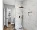 Walk-in shower featuring white marble-like tiles, a rainfall shower head, and a convenient built-in niche at 525 James Lee Dr, Suwanee, GA 30024